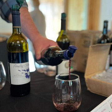 Winemaker pouring wine into a tasting glass