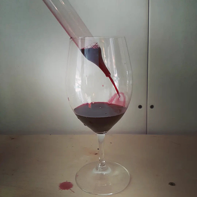 Glass of red wine poured from a barrel sample